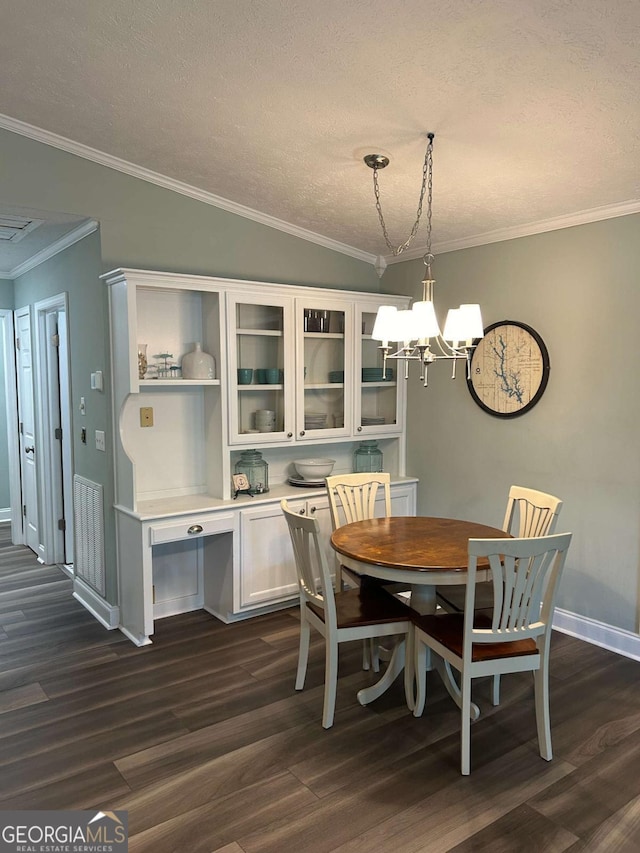 dining area featuring dark hardwood / wood-style floors, an inviting chandelier, and ornamental molding