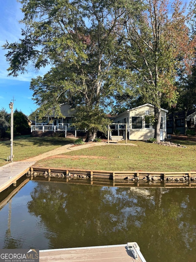 dock area featuring a lawn and a water view