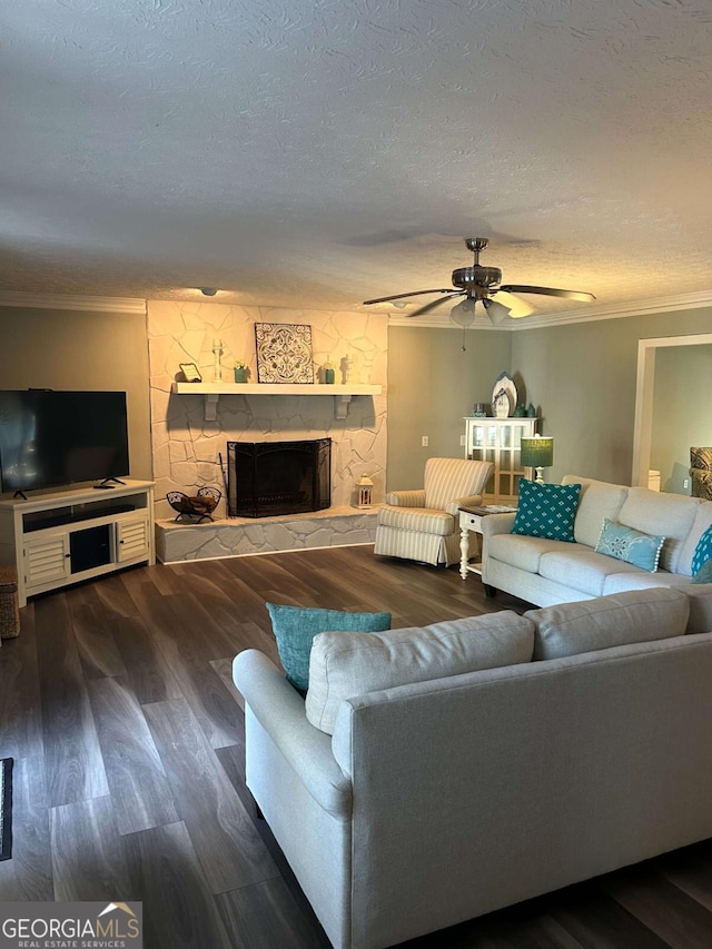 living room with a fireplace, dark hardwood / wood-style flooring, a textured ceiling, and ceiling fan