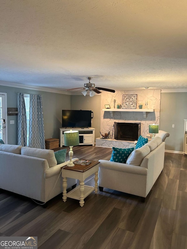 living room featuring a textured ceiling, a stone fireplace, ceiling fan, and dark wood-type flooring