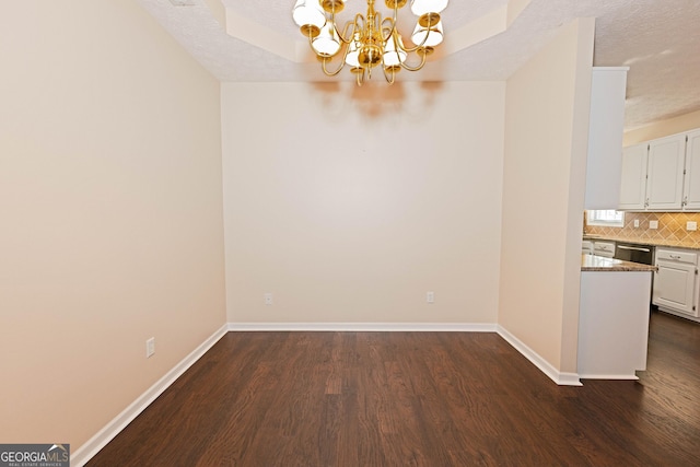 unfurnished dining area featuring a notable chandelier, dark hardwood / wood-style flooring, and a textured ceiling