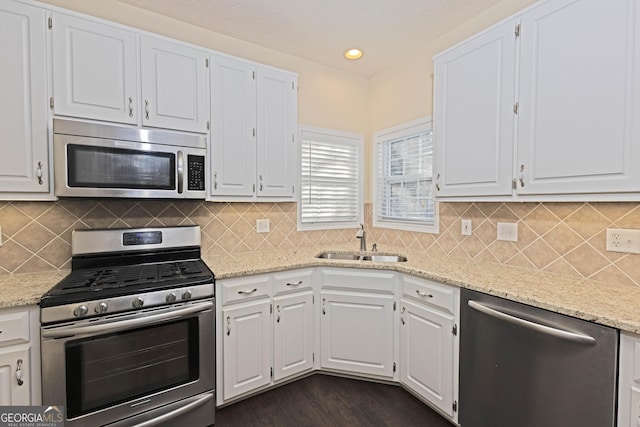 kitchen featuring decorative backsplash, sink, white cabinetry, and stainless steel appliances