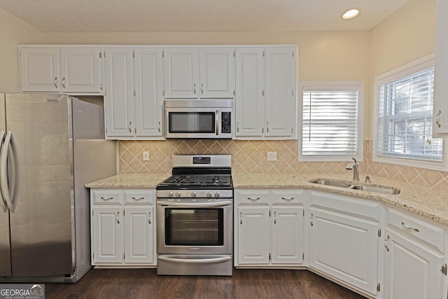 kitchen with stainless steel appliances, white cabinetry, and sink