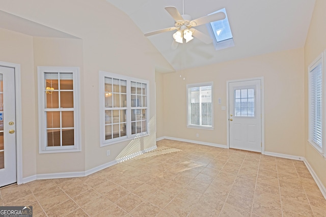 interior space featuring ceiling fan and vaulted ceiling with skylight