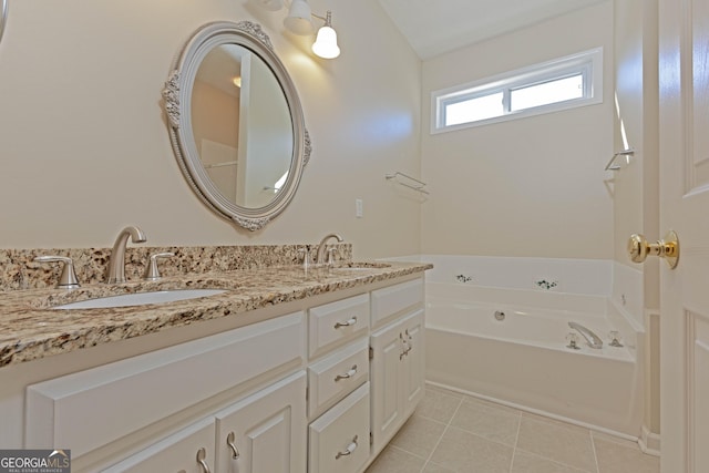 bathroom with tile patterned floors, a washtub, and vanity