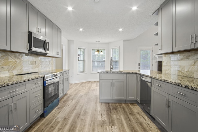 kitchen with sink, appliances with stainless steel finishes, gray cabinets, and tasteful backsplash