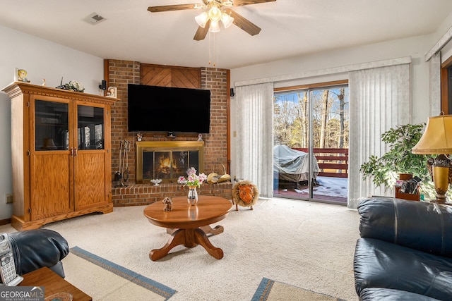 living room with a brick fireplace, carpet floors, and ceiling fan