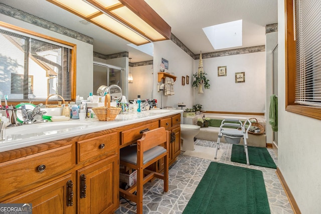 full bathroom featuring toilet, shower with separate bathtub, a skylight, and vanity