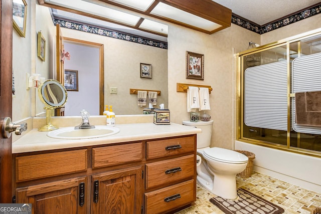 full bathroom with vanity, combined bath / shower with glass door, and toilet