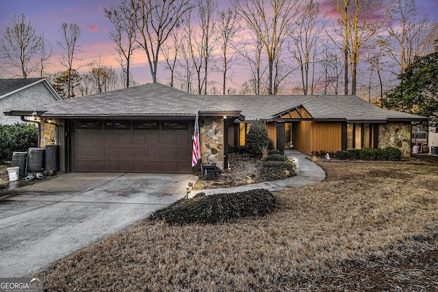 ranch-style home with a garage and a lawn