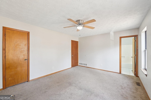 carpeted spare room with a textured ceiling and ceiling fan