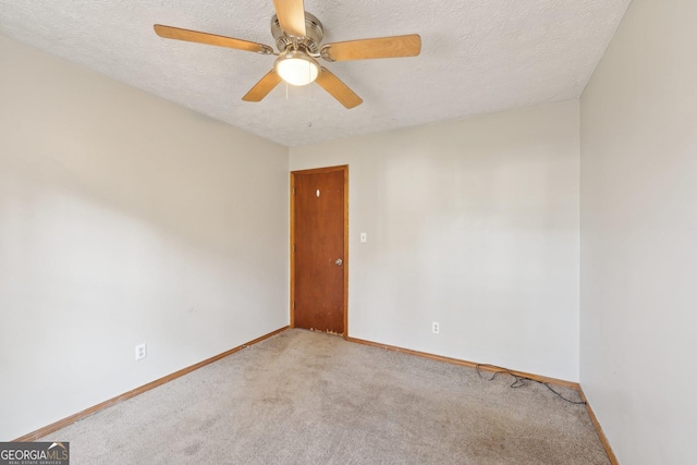 unfurnished room featuring light carpet, ceiling fan, and a textured ceiling