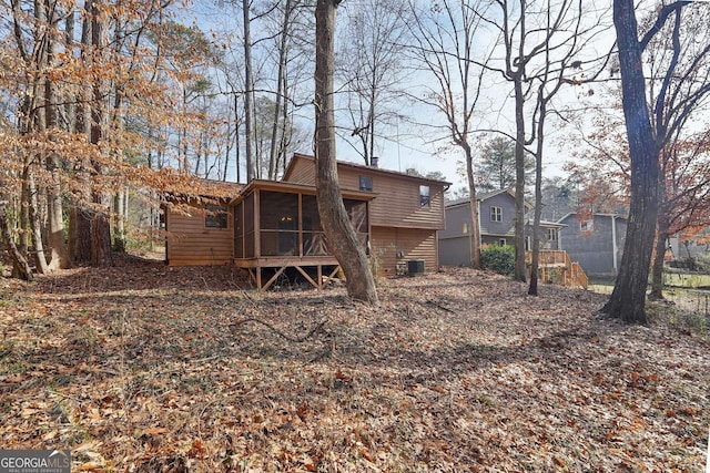 rear view of property featuring central AC unit and a sunroom