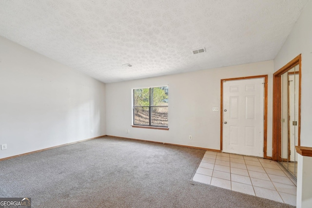 carpeted spare room featuring a textured ceiling