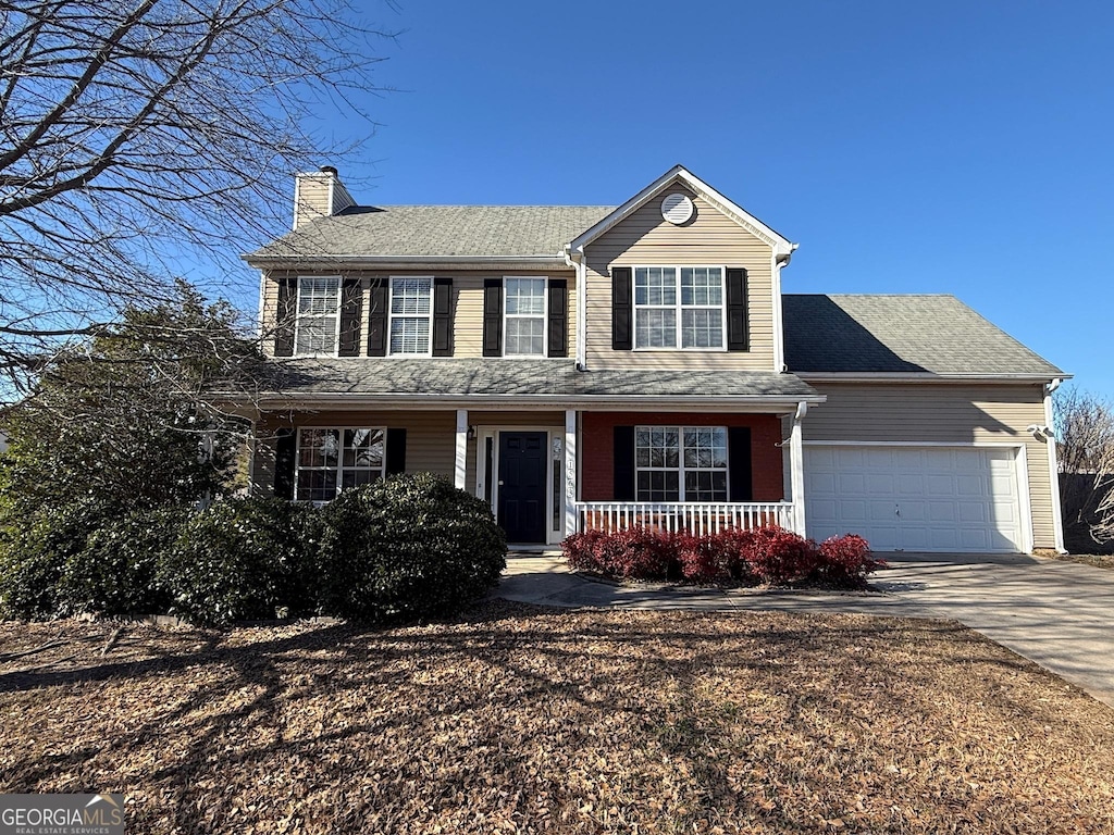 colonial house featuring a garage and a porch