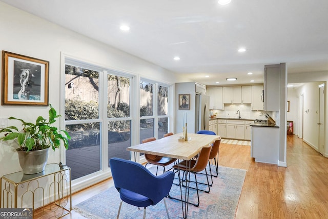 dining space featuring sink and light hardwood / wood-style flooring