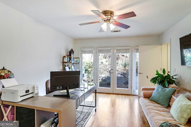 office with french doors, ceiling fan, and light wood-type flooring