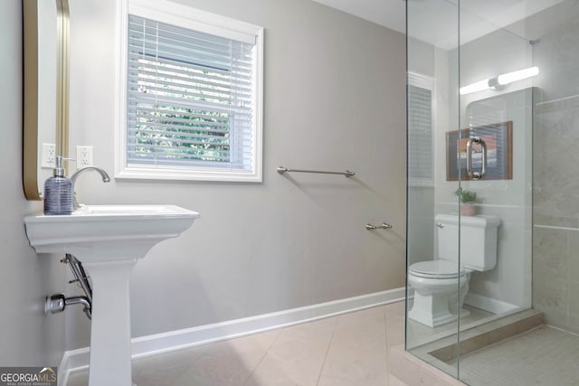 bathroom featuring tile patterned flooring, toilet, and walk in shower