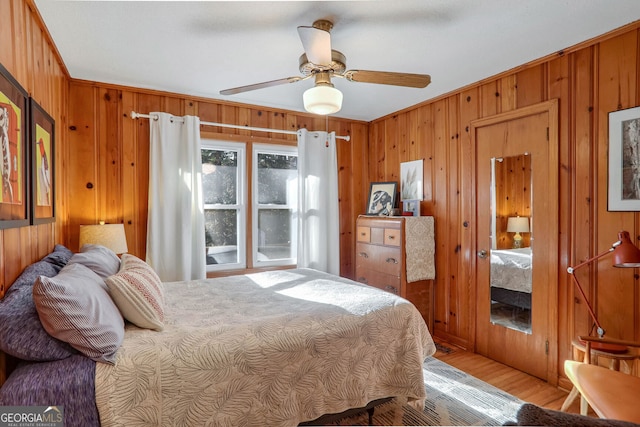 bedroom with crown molding, ceiling fan, and wood walls