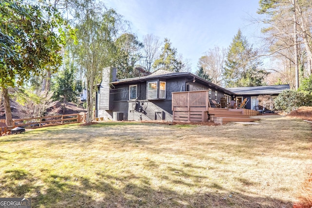 back of property featuring a wooden deck, central AC, and a lawn