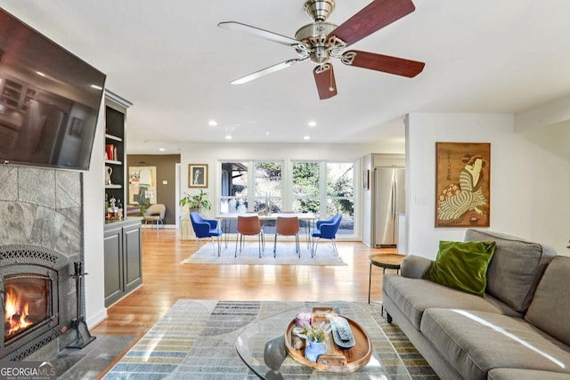 living room with a fireplace, light hardwood / wood-style floors, and built in shelves