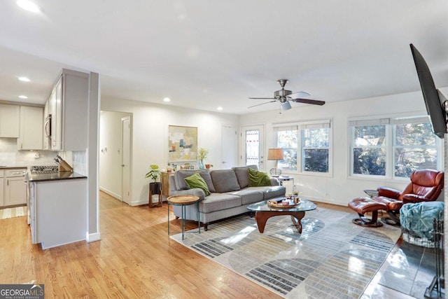 living room with ceiling fan and light hardwood / wood-style floors