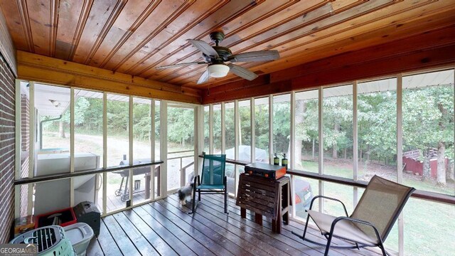 sunroom featuring a wealth of natural light, ceiling fan, and wood ceiling