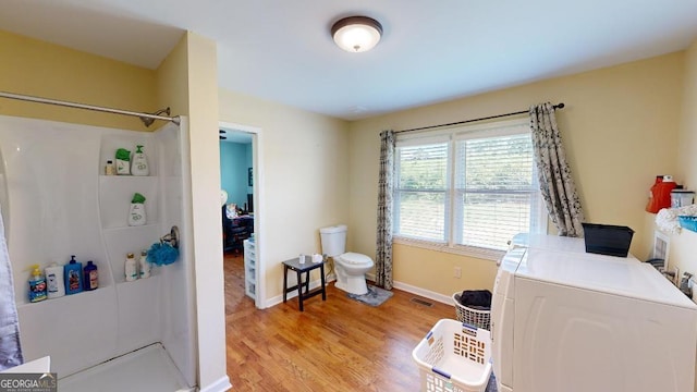 office space featuring washing machine and clothes dryer and light hardwood / wood-style flooring