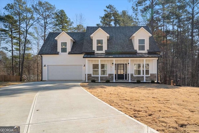 new england style home with covered porch and a garage