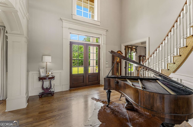 foyer featuring hardwood / wood-style floors, a high ceiling, and french doors