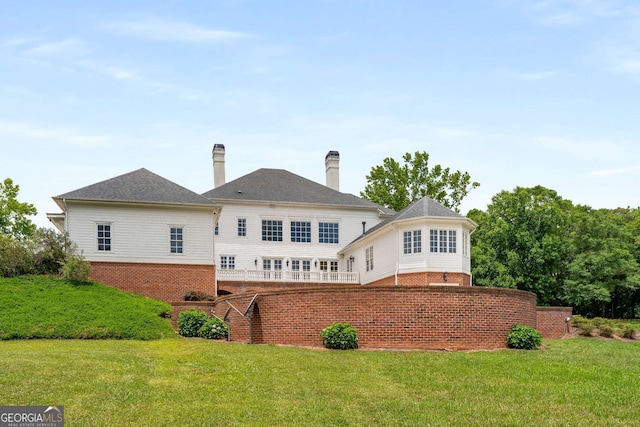 rear view of property featuring a lawn