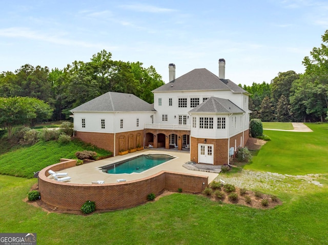 rear view of house with a lawn and a patio