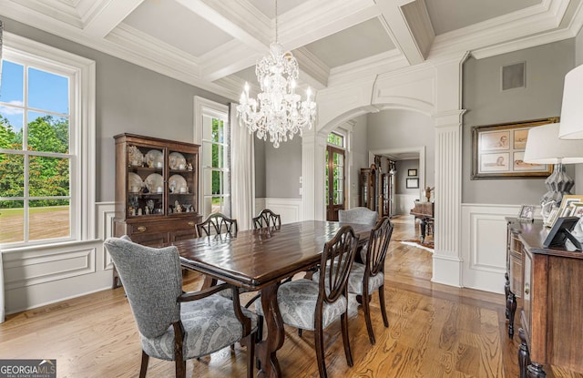 dining room featuring ornate columns, beamed ceiling, a healthy amount of sunlight, and ornamental molding