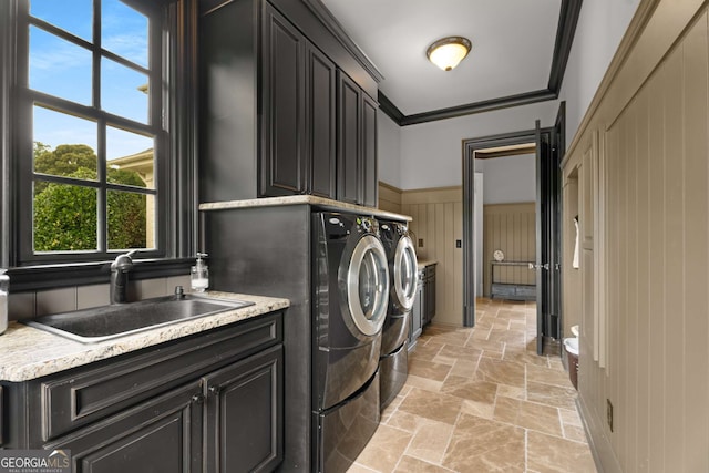 washroom with cabinets, crown molding, sink, and washing machine and clothes dryer