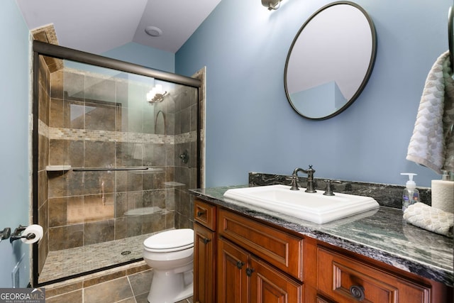 bathroom with vanity, a shower with shower door, vaulted ceiling, and toilet