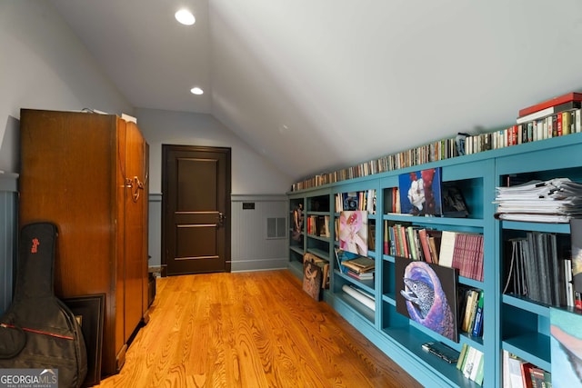 interior space with light wood-type flooring and vaulted ceiling