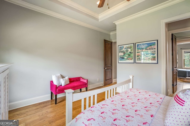 bedroom featuring hardwood / wood-style flooring, ceiling fan, and crown molding