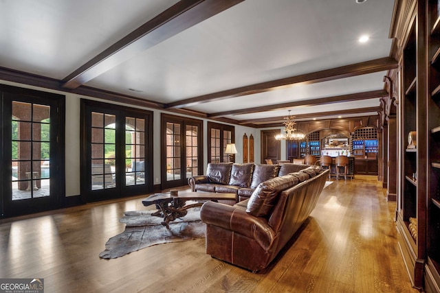 living room with french doors, crown molding, beamed ceiling, a notable chandelier, and wood-type flooring