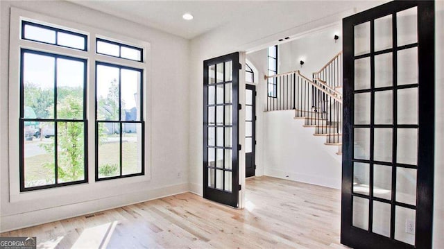 doorway to outside featuring light hardwood / wood-style flooring, french doors, and a wealth of natural light