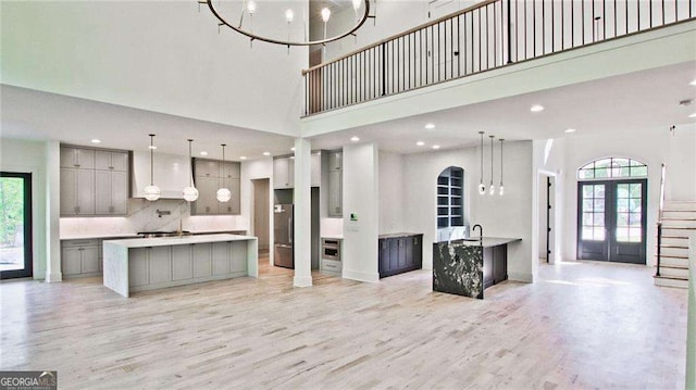 kitchen with gray cabinets, a large island, french doors, and a high ceiling