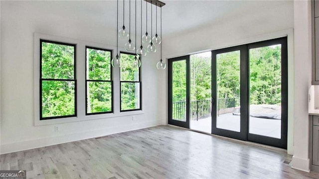 spare room featuring light hardwood / wood-style flooring and an inviting chandelier