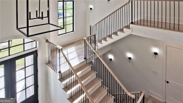 staircase with french doors and hardwood / wood-style floors