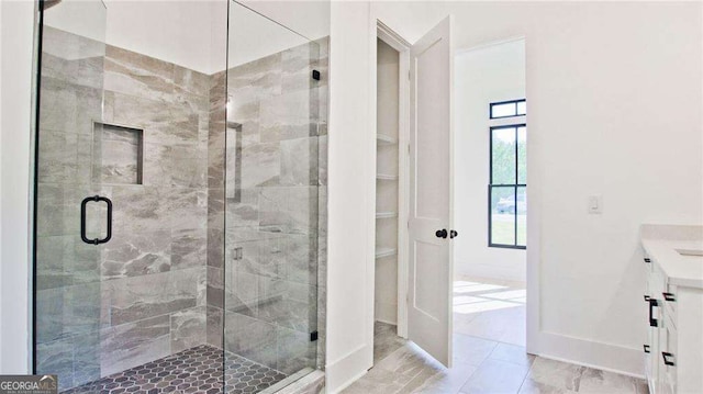 bathroom with a shower with door and vanity