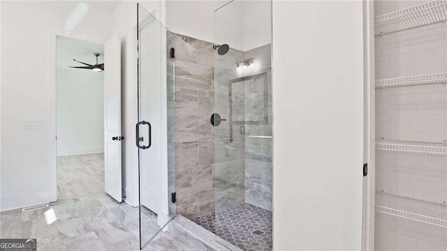 bathroom featuring ceiling fan and a shower with shower door