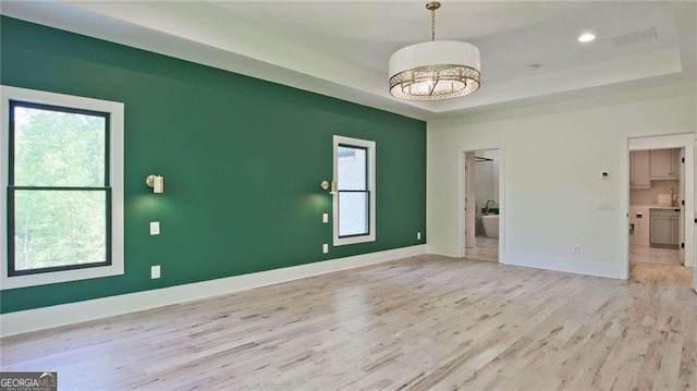 interior space with light hardwood / wood-style flooring and a tray ceiling