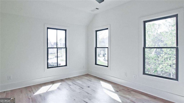 unfurnished room featuring light hardwood / wood-style floors and vaulted ceiling