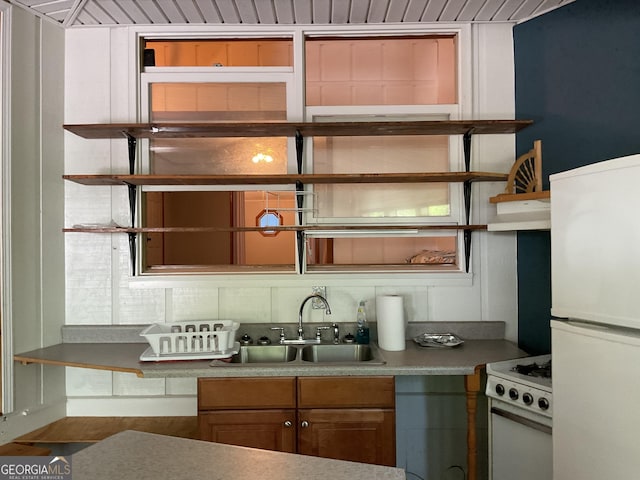 kitchen featuring backsplash, sink, and white appliances