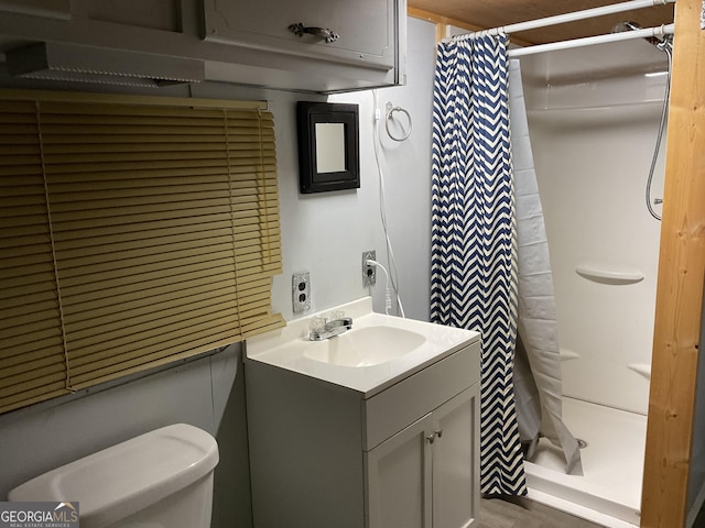 bathroom with toilet, vanity, and a shower with shower curtain