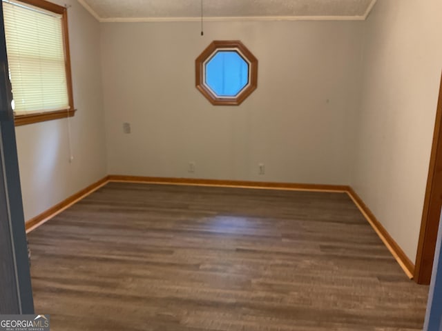 empty room featuring crown molding and dark hardwood / wood-style flooring