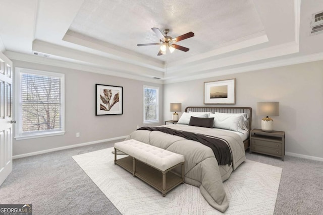 bedroom featuring light carpet, ornamental molding, and a raised ceiling